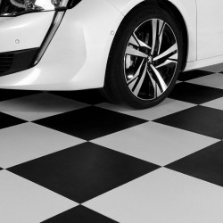 Vue d'un garage avec une voiture blanche. Le sol est fait avec des dalles PVC de la gamme Corvette (damier noir et blanc).