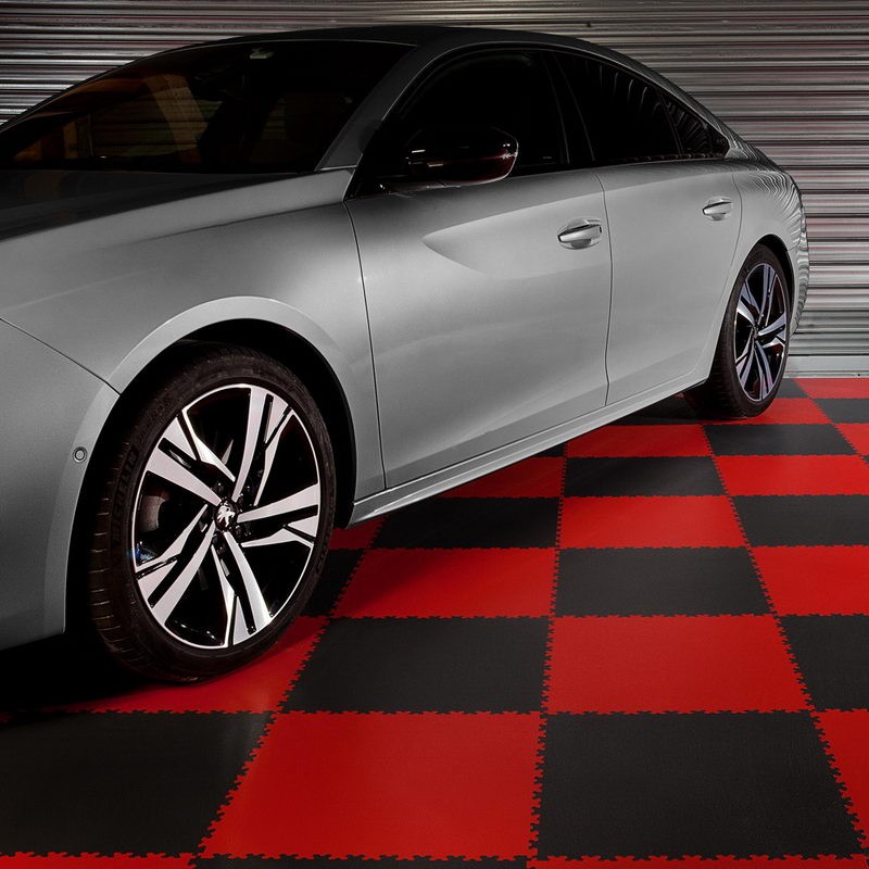 Photo d'une voiture grise sur un sol de garage fait d'un damier rouge et gris foncé de dalles Ghia en PVC